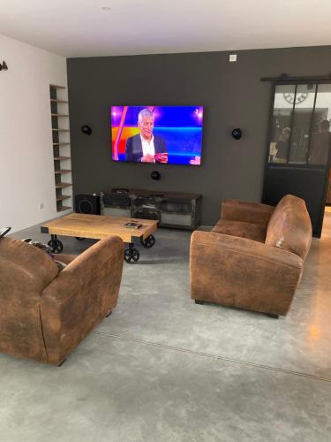 un salon avec deux canapés et une télévision à écran plat dans l'établissement Le Terminus de Jobourg, à Jobourg