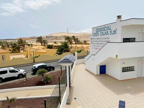 a view of a building with a car parked in a parking lot at Apartamento Vilem & Piscina, Wi-Fi in Costa Calma
