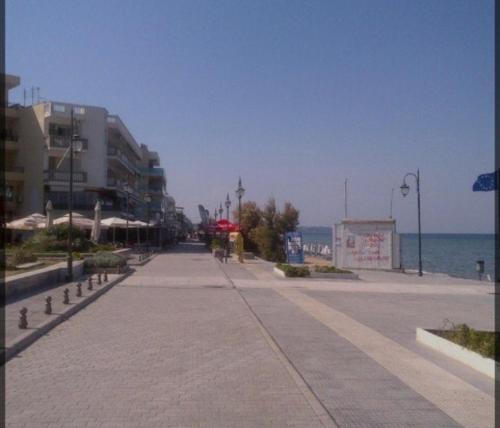 an empty sidewalk next to the ocean with buildings at Dellmar Apartment in Perea