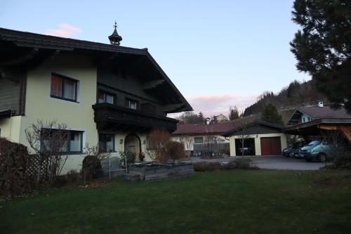 a house with a car parked in a yard at Landhaus-Appartements Warraich in Schladming