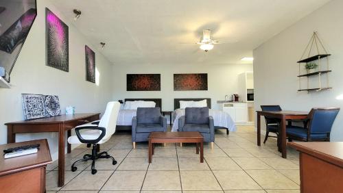a bedroom with a bed and a desk and chairs at Barefoot mailman motel in Lantana