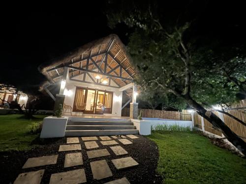 a house at night with a pathway leading up to it at White Hut Villas by Asog resort in Naga