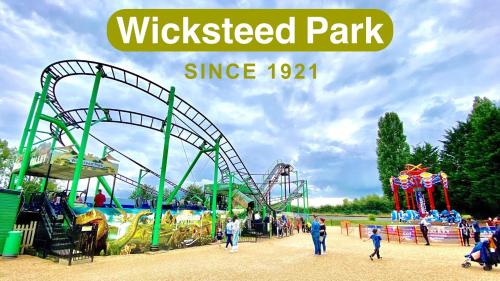an amusement park with a roller coaster and people walking around it at Acaster House, x4 rooms with en-suites x1 room private bathroom, street parking, close to train station in Kettering