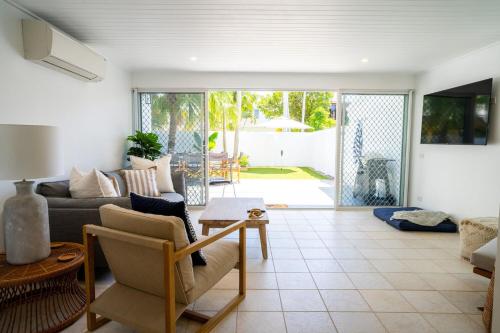 a living room with a couch and a table at The Oasis has a private courtyard and ideal location to walk in Noosa Heads