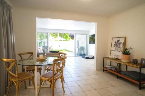a dining room with a glass table and chairs at The Oasis has a private courtyard and ideal location to walk in Noosa Heads
