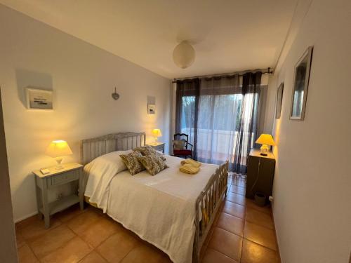 een slaapkamer met een bed, 2 lampen en een raam bij Les Collines d'Estanove, charming, bright, calm place with pool in Montpellier