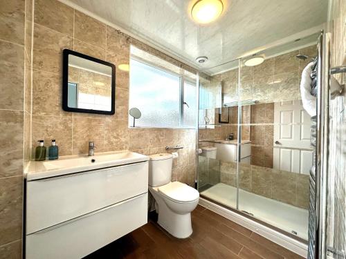 a bathroom with a toilet and a sink and a shower at Spacious 3 double bedroomed house in Bicester in Bicester