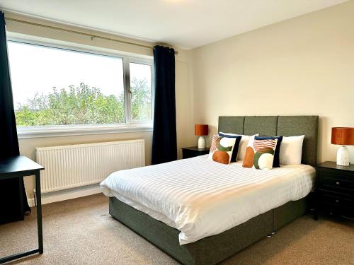 a bedroom with a bed and a large window at Spacious 3 double bedroomed house in Bicester in Bicester