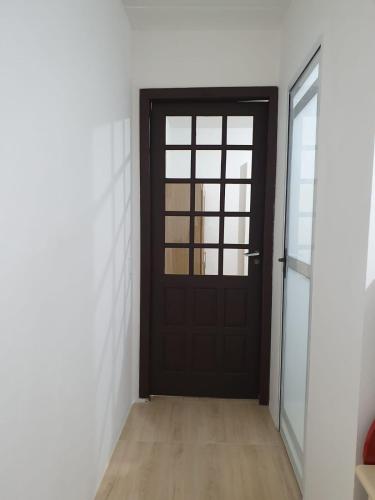 a black door in a room with a wooden floor at Pousada Korb in Santo Amaro da Imperatriz