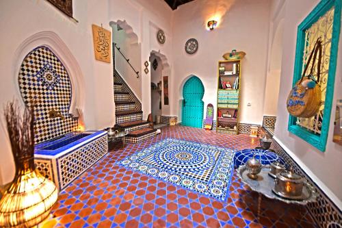a room with a tiled floor with a blue door at Darna Hostel in Tétouan