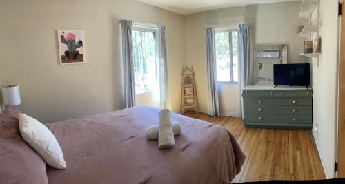 un dormitorio con una cama con un animal de peluche en Vintage charm vacation home with modern comforts near Old Town en Albuquerque
