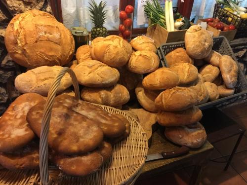 a bunch of loaves of bread and buns on a table at Alojamientos Turisticos La Utrera in Las Majadas