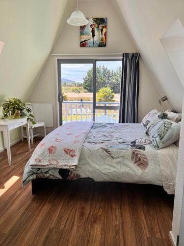 a bedroom with a bed and a large window at Green Tree Haven BnB-Riwaka Tasman Bay in Riwaka