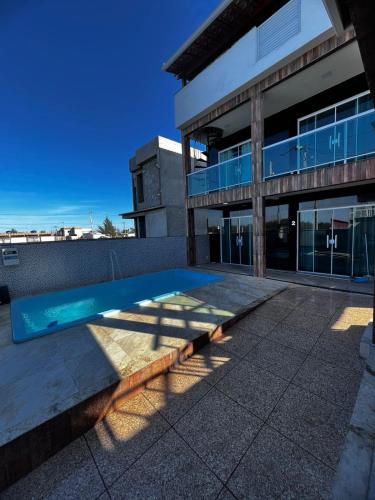a swimming pool in front of a building at Águas Rasas - Flats in Arraial do Cabo