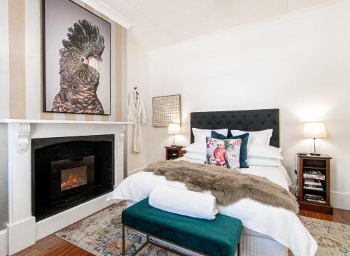 a bedroom with a bed and a fireplace at 70 On Mortimer in Mudgee