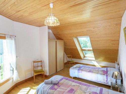コンカルノーにあるSpacious Villa in Concarneau with Swimming Poolの木製の天井が特徴のベッドルーム1室(ベッド2台付)