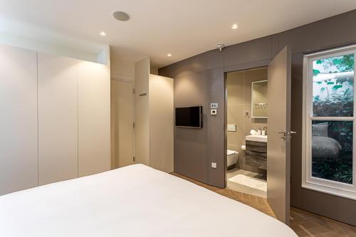 a bedroom with a white bed and a bathroom at Mews house in London