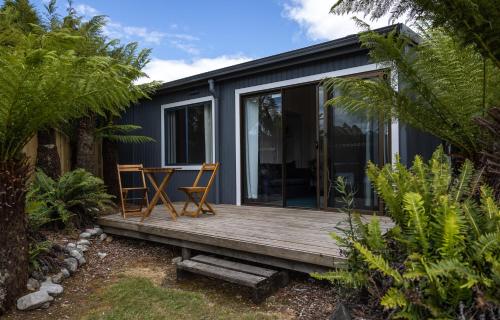 a house with a wooden deck with a table on it at Tullah Lakeside Lodge in Tullah