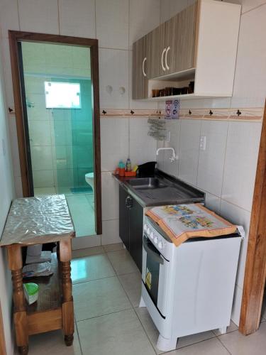 una pequeña cocina con fogones y fregadero en Apartameto 2 quartos perto da praia e Beto Carrero, en Penha
