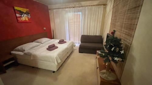 um pequeno quarto com uma cama e uma cadeira em Apartman Adel em Veľká Lomnica