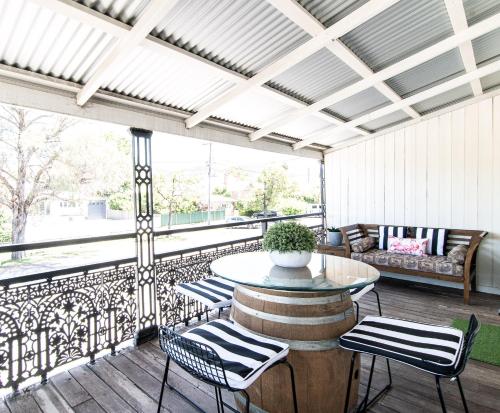 a screened in porch with a table and chairs at 70 On Mortimer in Mudgee