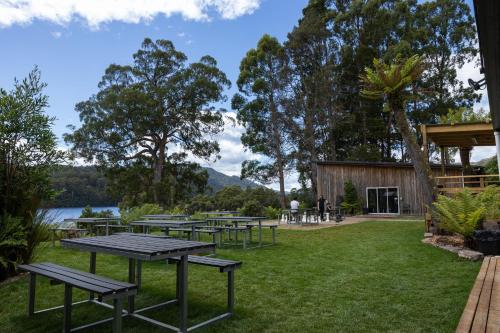 a group of picnic tables on the grass near a lake at Tullah Lakeside Lodge in Tullah