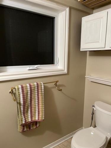 a bathroom with a toilet and a window and a towel at Mulberry court in Windsor