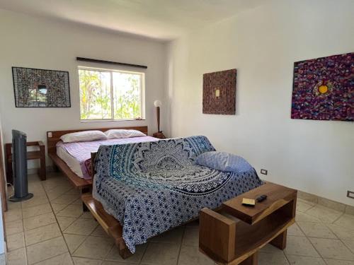 a bedroom with two beds and a table at Puesta del Sol in Quepos