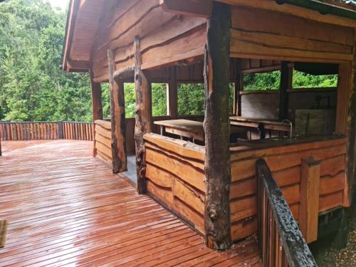 a porch of a wooden cabin with a wooden deck at HuiloHuilo San Avellano en Reserva Biologica in Huilo Huilo
