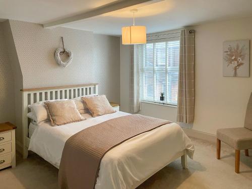 een slaapkamer met een groot bed en een raam bij Driftwood Cottage in Gorleston-on-Sea