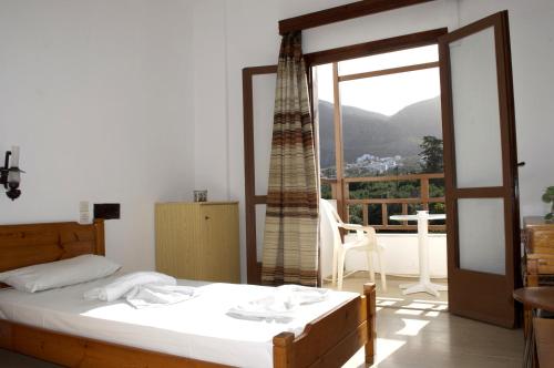 a bedroom with a bed and a window with a view at Hotel Velissarios in Hersonissos