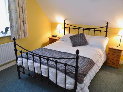 a bedroom with a large bed and two night stands at Penny Corner in Whitchurch Canonicorum