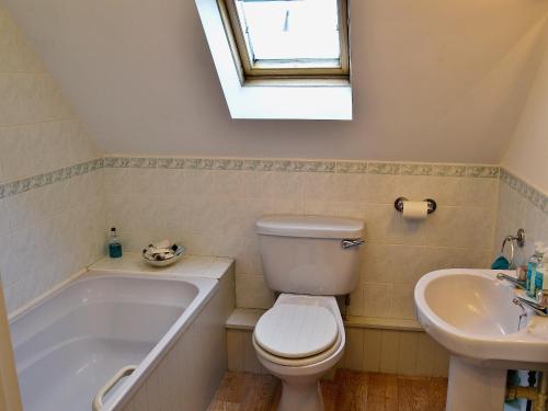 a bathroom with a toilet and a sink and a tub at Penny Corner in Whitchurch Canonicorum