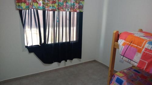 Habitación con ventana con cortina y cama en Alojamientos Malargüe en Malargüe