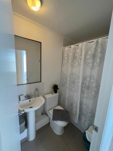 La salle de bains est pourvue d'un lavabo, de toilettes et d'un miroir. dans l'établissement descanso y paz, à Caldera