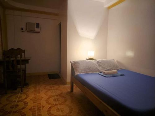 - une chambre dotée d'un lit bleu avec une lampe dans l'établissement Deja Homestay Siargao, à Del Carmen