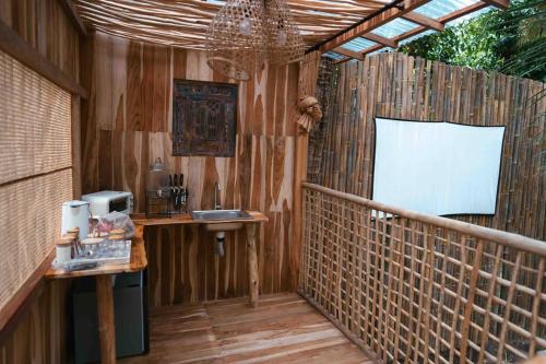 un patio con fregadero y una valla de madera en Romantic DOME with hot jacuzzi and Jungle view, en Klungkung