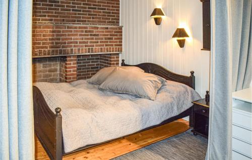 a bed in a room with a brick wall at Lovely Home In Vler I stfold With Jacuzzi 