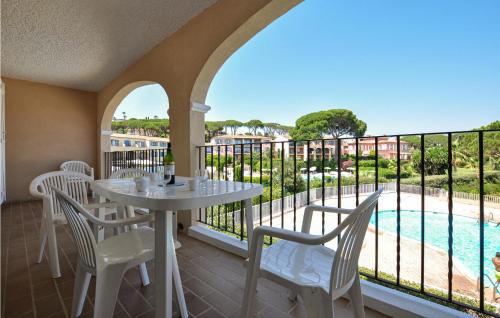 a balcony with a table and chairs and a pool at Amazing Apartment In Sainte-Maxime in Sainte-Maxime