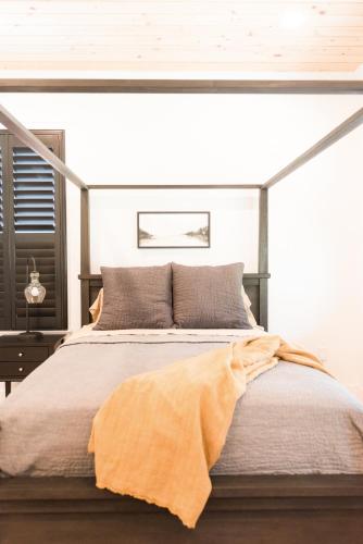 a bedroom with a bed with an orange blanket on it at Haven House in Pensacola