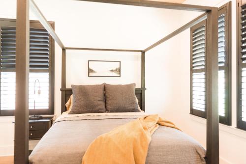 a bedroom with a large bed in a room with windows at Haven House in Pensacola