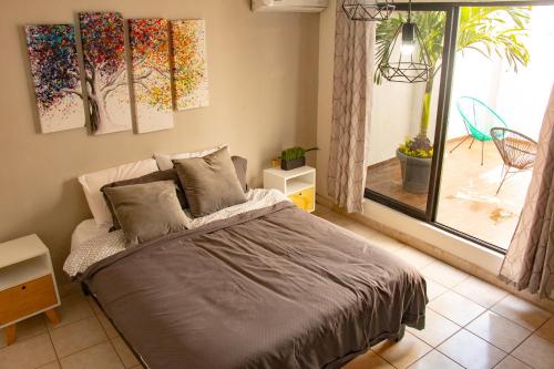 Schlafzimmer mit einem Bett mit Gemälden an der Wand in der Unterkunft Departamento Olas in Tuxtla Gutiérrez