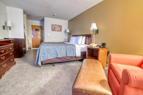 a hotel room with a bed and a couch at Econo Lodge in Raleigh