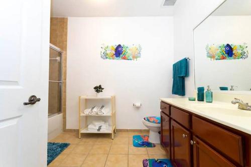 La salle de bains est pourvue d'un lavabo et de toilettes. dans l'établissement Beautiful Orlando Apt with Nemo Bedroom, 15 min to Disney!, à Kissimmee