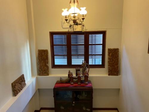 a chandelier and a window in a room at Baan Klang Vieng in Chiang Mai