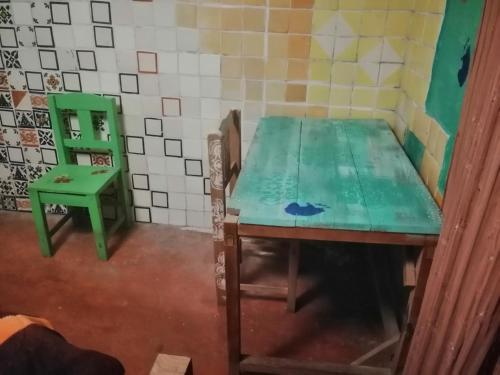 a green table and a green chair in a room at Casa Kasa Hostel in San Cristóbal de Las Casas