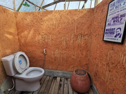a bathroom with a toilet and a sign on a wall at Harvest Moon Valley in Ban Pang Luang