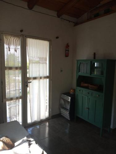 una sala de estar con un armario verde y puertas correderas de cristal en Terrazas del Río en Achiras