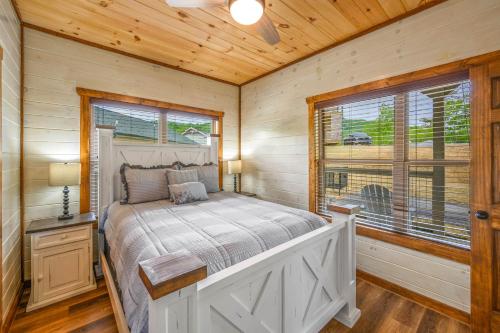 - une chambre avec un lit et une fenêtre dans l'établissement Osprey Nest Cottage Modern New Cabin, à Pigeon Forge