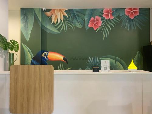 a wall with a painting of a bird on a counter at CASA CALMA HOTEL in Jakarta